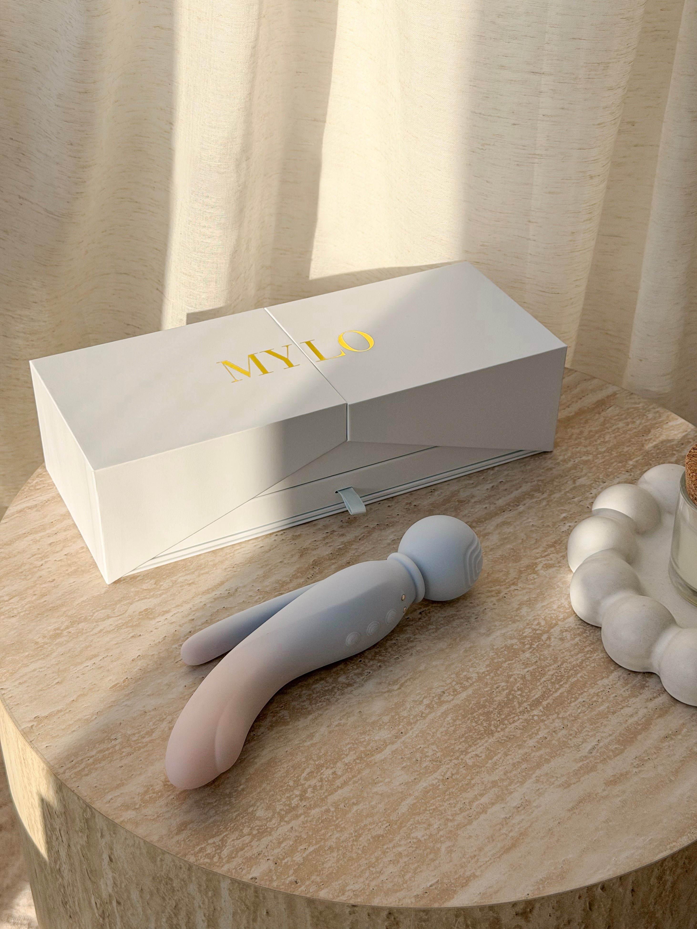 A sleek, pastel blue and pink gradient silicone toy with a rounded head and two slender appendages.