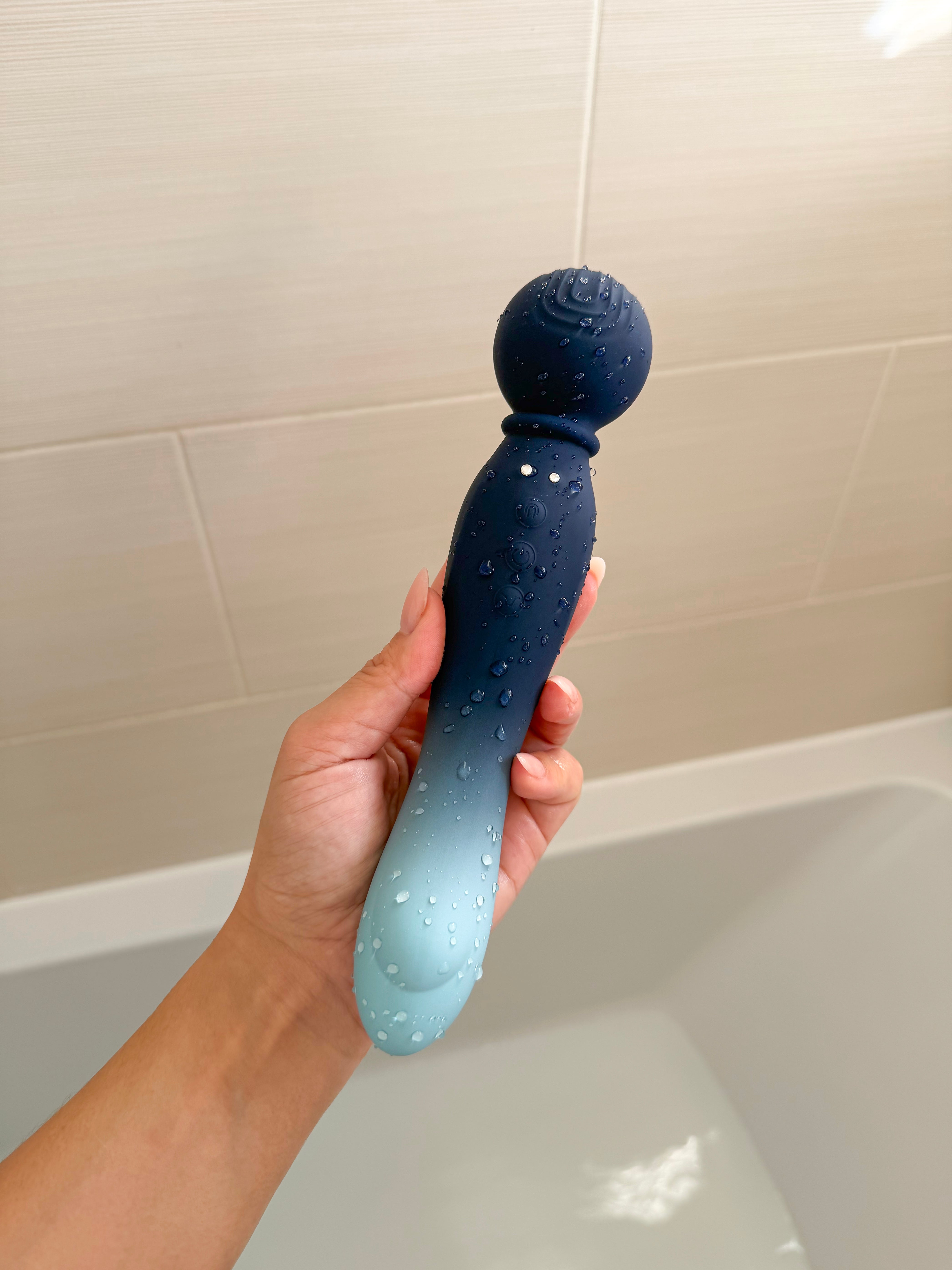 A sleek, gradient blue silicone toy with a textured spherical head and subtle white dots along its body.